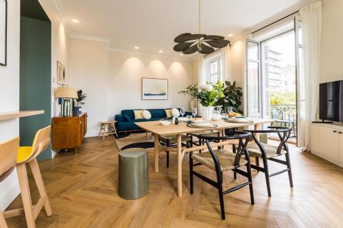 een eetkamer en een woonkamer met een tafel en stoelen bij HYGGE KEYWEEK Apt 2 bedrooms with parking in Biarritz city center in Biarritz