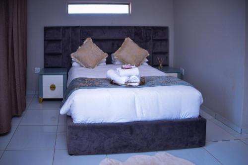 a bedroom with a large bed with two towels on it at La mbeu concierge in Thohoyandou