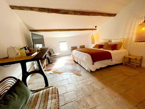 a bedroom with a bed and a desk in a room at La Maison de Lyna - Suites de charme intra-muros avec parking & autonomie in Aigues-Mortes