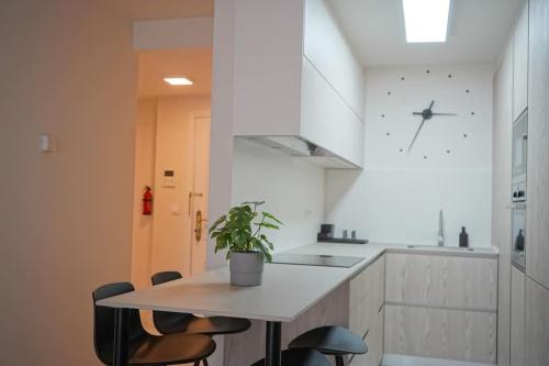 eine Küche mit Tisch und Stühlen und einer Uhr in der Unterkunft Apartamento en la playa de Brazomar wifi y garaje in Brazomar