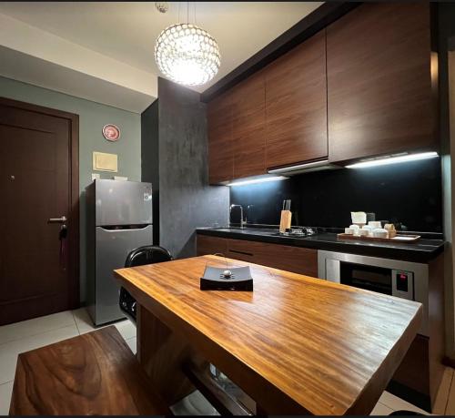 eine Küche mit einem Holztisch und einem Kühlschrank in der Unterkunft 2 Bedrooms - Thamrin Executive Apartment at Jakarta Center in Jakarta