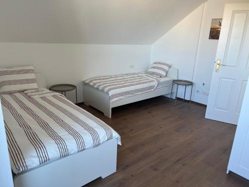 2 camas en una habitación con suelo de madera en Ruhige Grüne Oase bei Flughafen Schwechat en Schwechat