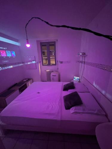 een paarse kamer met een bed en een bureau bij Jacuzzi au cœur de Bordeaux in Bordeaux