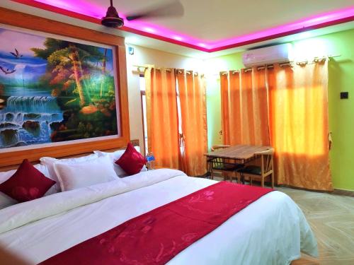 a bedroom with a bed and a painting on the wall at Hotel National Park Sauraha- Homely Stay and Peaceful Location with Jungle Safari arrangements in Sauraha