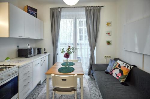 a kitchen and living room with a table and a couch at Cosy & Charming In The City Centre in Vienna