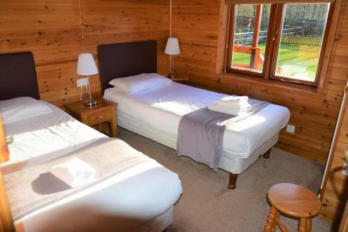 a bedroom with two beds and a window at Woolpack Lodge in Holmrook