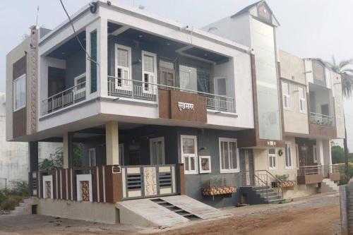 Edificio blanco con porche y balcón en Sukh Sagar Homestay, en Chittorgarh