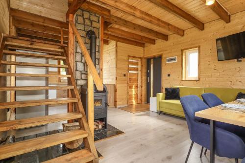 a log cabin living room with a staircase and a fireplace at Jaśkowe Wzgórze domki na wynajem, balia, Szymbark DOMEK NR 1 in Szymbark