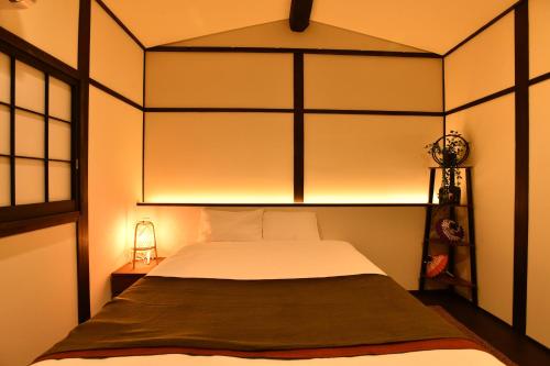 a bedroom with a bed with a light above it at ＦＬ　ＨＯＵＳＥ浪速・桜畔 in Osaka