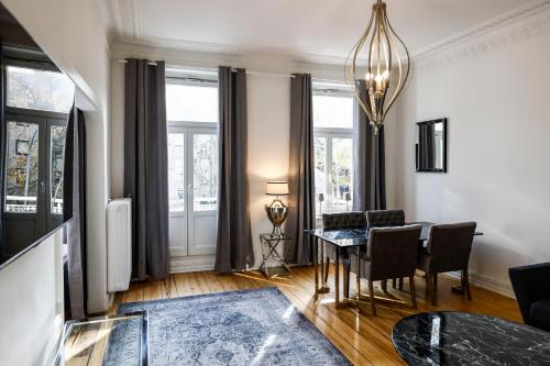 a living room with a table and chairs and windows at Sleephotels Alsterroom in Hamburg