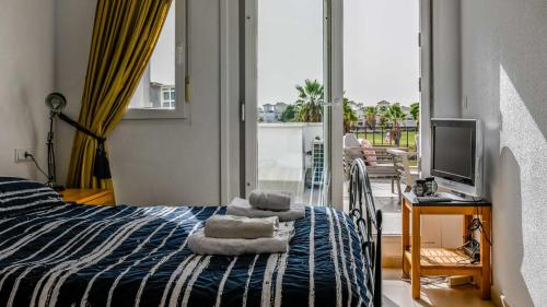 a bedroom with a bed and a television and a balcony at Modern Stunning Townhouse 3 bed 2 bath on La Torre CE51LT in Torre-Pacheco