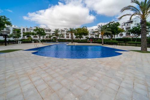 a pool in a courtyard with palm trees and buildings at Modern Stunning Townhouse 3 bed 2 bath on La Torre CE51LT in Torre-Pacheco