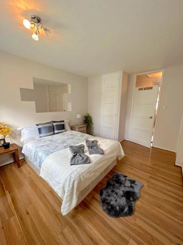 - une chambre avec un grand lit et du parquet dans l'établissement 303 Alexandra Avenue HA2 9DX, à Pinner