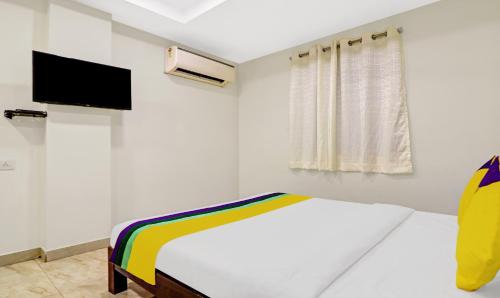 a white bedroom with a bed and a tv at Itsy Hotels Infinity, Hitech City in Hyderabad