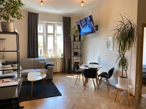 - un salon avec un canapé, une table et des chaises dans l'établissement Apartament przy plaży w centrum Gdyni - prywatny parking!, à Gdynia