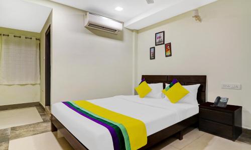 a bedroom with a bed with a colorful blanket on it at Itsy Hotels Infinity, Hitech City in Hyderabad