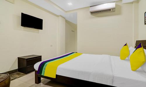 a bedroom with a white bed and a tv at Itsy Hotels Infinity, Hitech City in Hyderabad
