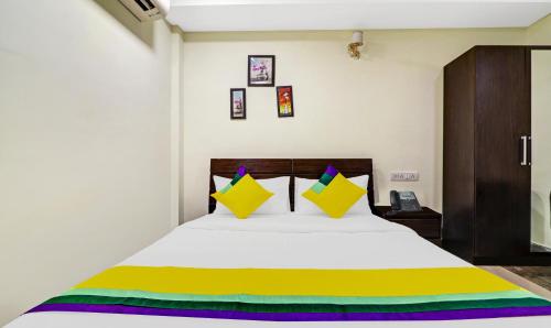 a bedroom with a bed with yellow and colorful pillows at Itsy Hotels Infinity, Hitech City in Hyderabad