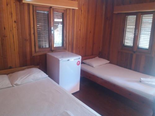 Zimmer mit 2 Betten, einem Kühlschrank und Fenstern in der Unterkunft Oll garden in Side
