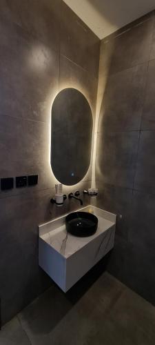 La salle de bains est pourvue d'un lavabo et d'un miroir. dans l'établissement Black, à Al-Ula