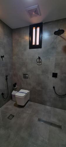 a bathroom with a toilet and a window at Black in AlUla