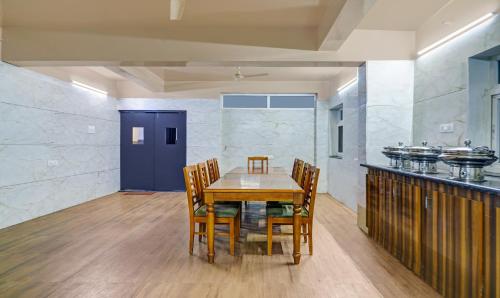 a dining room with a wooden table and chairs at Itsy Hotels Infinity, Hitech City in Hyderabad