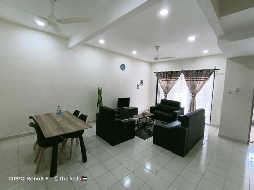 a living room with couches and a table and a dining room at Homestay Sofiyyah 1 in Temerloh