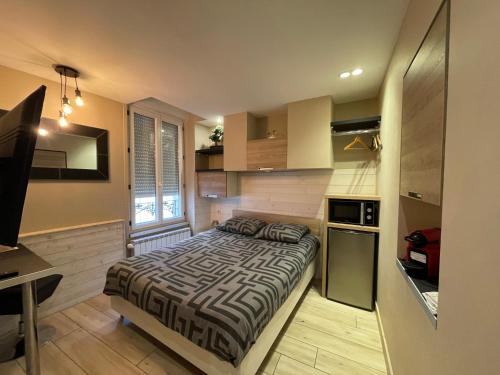 une chambre avec un lit dans une petite pièce dans l'établissement RDC 1 - Chambre meublée au cœur du centre ville de Montluçon, à Montluçon