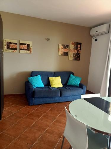 a living room with a blue couch and a table at Sal&Love apt in Porto Antigo in Santa Maria