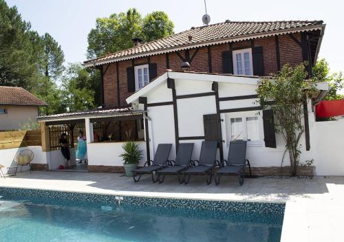 una casa con sillas junto a una piscina en Gîte Villa Paul Herm, en Herm