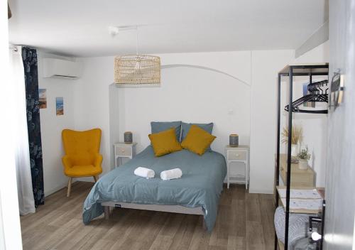 1 dormitorio con 1 cama y 1 silla amarilla en Gîte Villa Paul Herm, en Herm