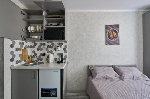 a bedroom with a bed and a kitchen with a counter at Апарт 33 in Almaty