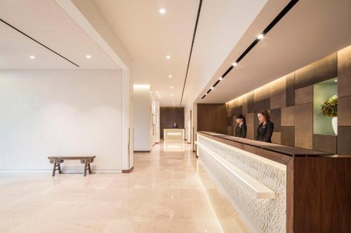 a lobby with two people standing at a counter at COMO Metropolitan London in London