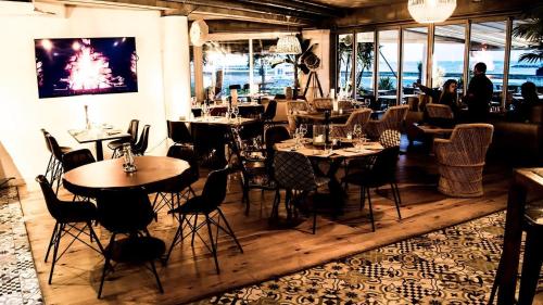 un restaurante con mesas y sillas en una habitación en Résidence de Tourisme l'Albatros en Palavas-les-Flots