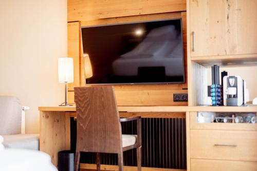 a room with a desk with a television and a chair at Avita Resort Bad Tatzmannsdorf in Bad Tatzmannsdorf