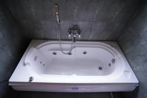 a white bath tub with a faucet in a bathroom at Ravishing Retreat Resort in Rāmanagaram