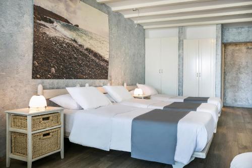 a bedroom with four beds and a painting on the wall at Ilio Maris in Mikonos