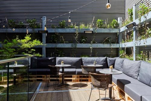 a patio with two tables and a couch at Hotel Indigo Antwerp City Centre by IHG in Antwerp