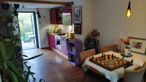 uma cozinha com uma mesa com um tabuleiro de xadrez em Atelier & Gardenhouse Glamping em Munique