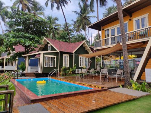 a house with a swimming pool in front of it at The Ark Comforts in Palolem