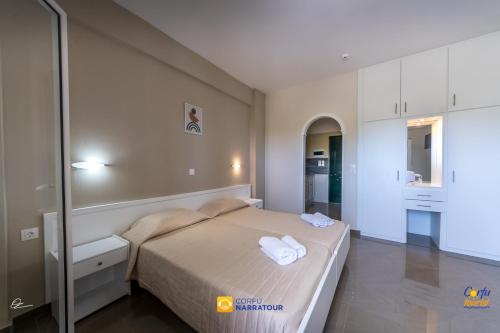 a bedroom with a bed with two towels on it at Chandris Apartments in Kavos