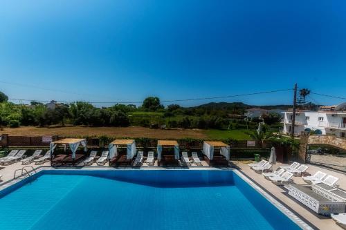 a swimming pool with lounge chairs at Chandris Apartments in Kavos