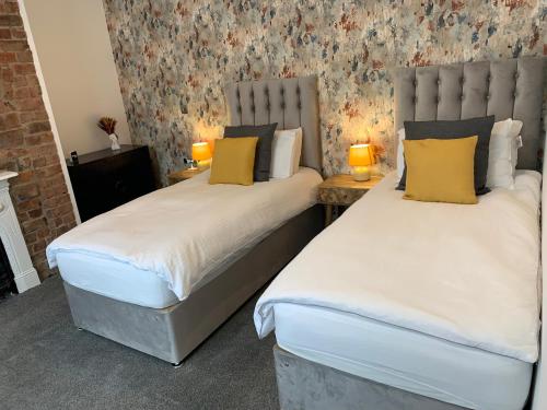 two beds sitting next to each other in a room at Ashfield Boutique Stays in Altrincham