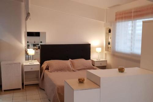 Un dormitorio con una cama grande y dos mesas. en Departamento luminoso amplio y silencioso., en Rosario