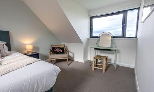 a bedroom with a bed and a desk and a window at 15 - 3 Bedroom Cottage - LP in Nefyn