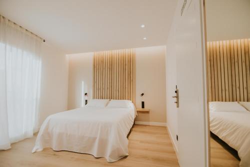 a bedroom with two beds and a mirror at Casa La Picuda in San Vicente de la Sonsierra