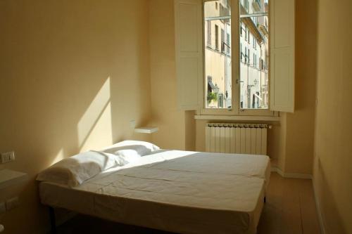 łóżko w pokoju z oknem w obiekcie Modern 3BR Near Santa Maria Novella Station we Florencji