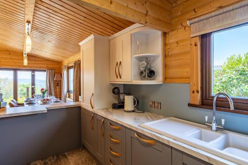 a kitchen with wooden cabinets and a sink and a window at Screel View in Kippford