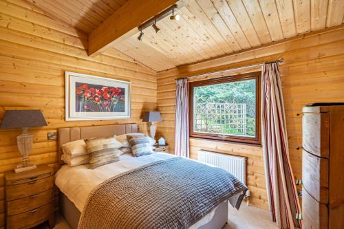 a bedroom with a bed in a wooden cabin at Screel View in Kippford