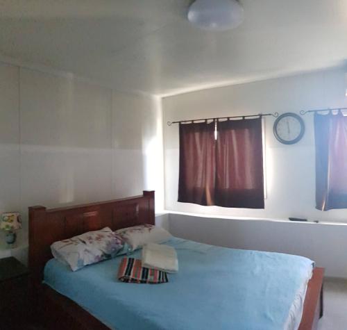 a bedroom with a bed with blue sheets and a window at Cozy Flat with Parking well-placed near TLV Airport in Lod
